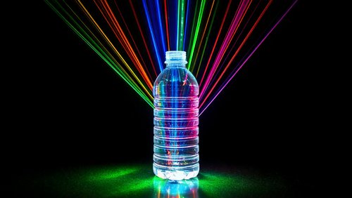 Kunststoffflasche wird mit Laserstrahlung verschiedener Wellenlängen bestrahlt