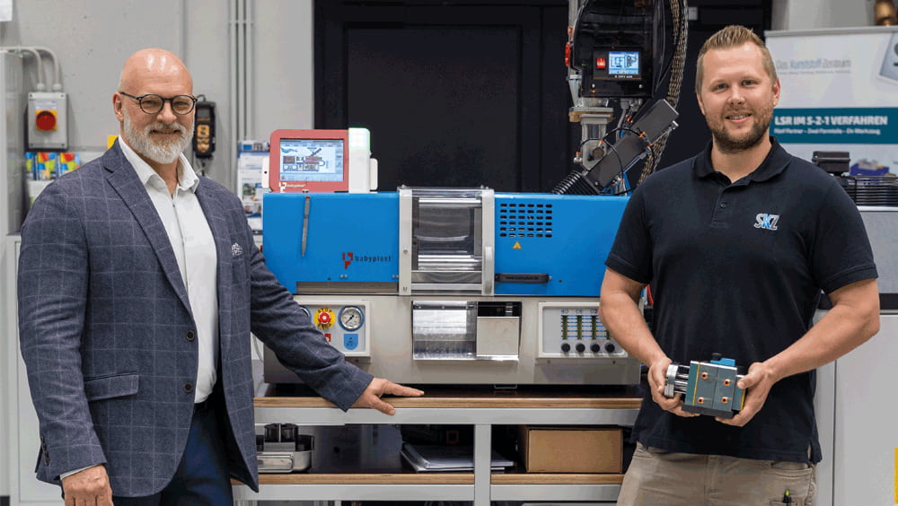 Marc Tesche (links), Geschäftsführer CHRISTMANN Kunststofftechnik GmbH, und Christoph Mussauer (rechts), Leitung Spritzgießtechnikum, vor der neuen SKZ-Maschine mit einem ersten Werkzeug Marc Tesche (links), Geschäftsführer CHRISTMANN Kunststofftechnik GmbH, und Christoph Mussauer (rechts), Leitung Spritzgießtechnikum, vor der neuen SKZ-Maschine mit einem ersten Werkzeug